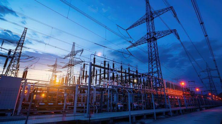 electric power station at sunset with multiple transmission towers and electrical equipment under a vibrant blue and orange sky premium photo