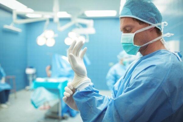 Male surgeon wearing surgical gloves in operation theater _ Premium Photo